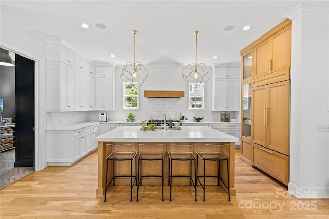 2509 Bay St, Charlotte, NC 28205 - kitchen featuring paneled built in refrigerator, light countertops, light wood-style floors, a kitchen bar, and tasteful backsplash