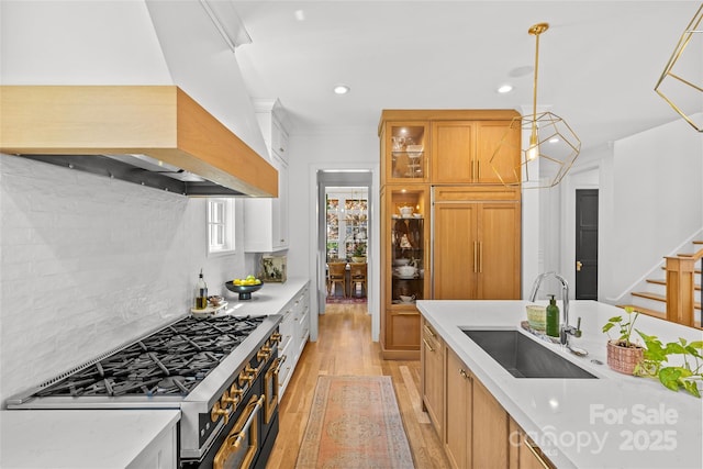 2509 Bay St, Charlotte, NC 28205 - kitchen with a sink, premium range hood, stainless steel gas range, light wood-style flooring, and backsplash