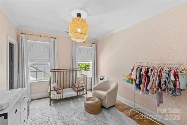 2509 Bay St, Charlotte, NC 28205 - bedroom featuring wood finished floors, wallpapered walls, crown molding, and baseboards