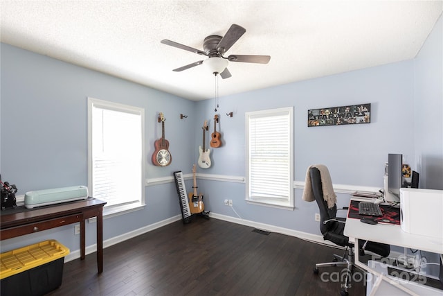 office area with baseboards, visible vents, ceiling fan, and dark wood-type flooring