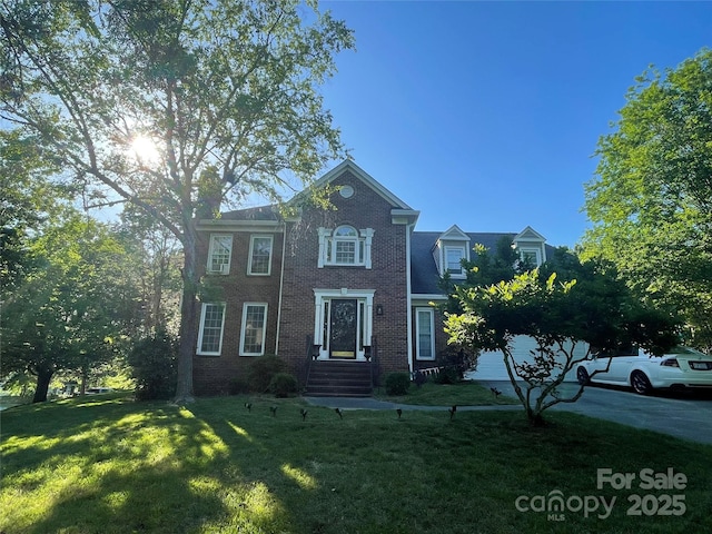 colonial home featuring brick siding and a front yard
