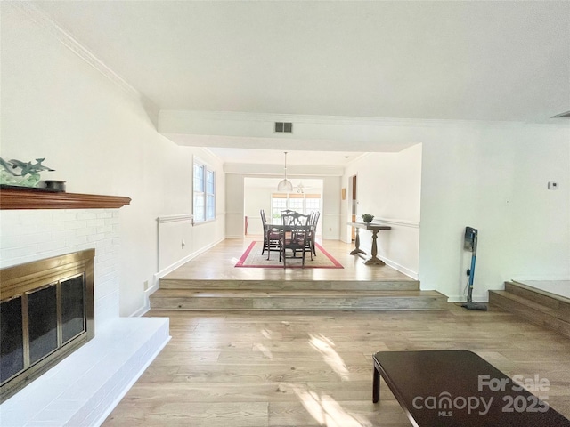 944 Evian Ln, Matthews, NC 28015 - unfurnished living room with crown molding, wood finished floors, a brick fireplace, and baseboards