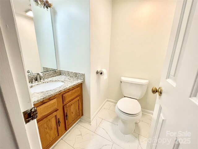 944 Evian Ln, Matthews, NC 28015 - bathroom featuring marble look tiles, toilet, vanity, and baseboards