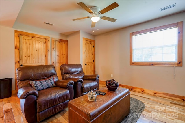 living area featuring ceiling fan, visible vents, and light wood-style flooring