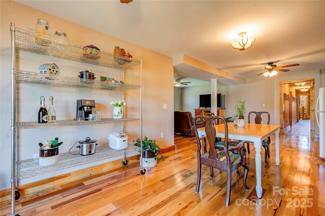 dining room with baseboards, ceiling fan, and hardwood / wood-style flooring