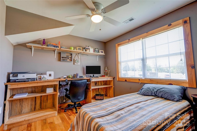 bedroom with visible vents, ceiling fan, wood finished floors, and lofted ceiling