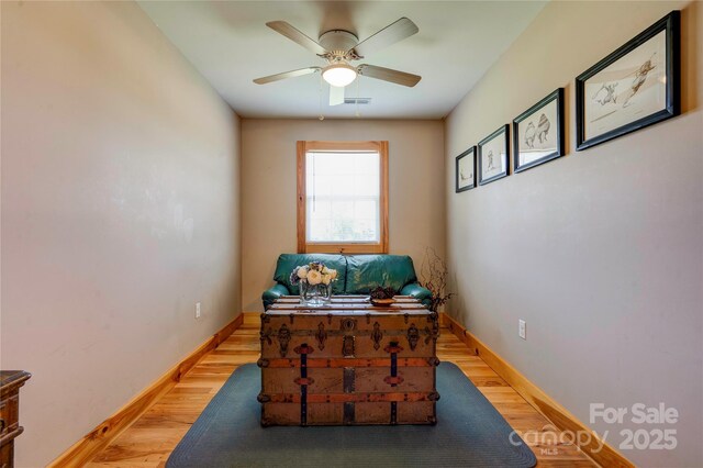 office area with baseboards, ceiling fan, light wood-style flooring, and visible vents