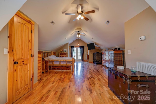 bedroom featuring visible vents, lofted ceiling, and light wood-type flooring