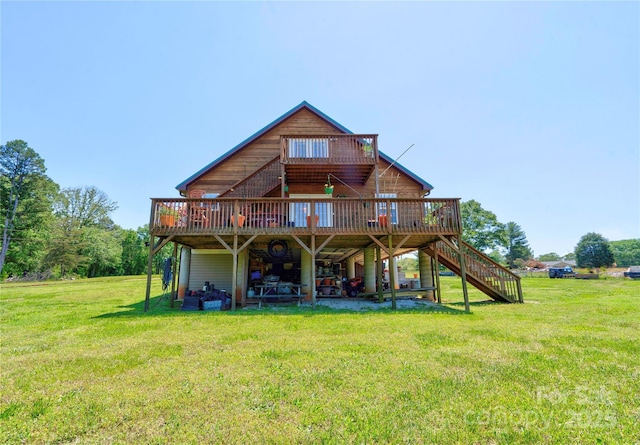 rear view of house with a yard, a wooden deck, and stairs