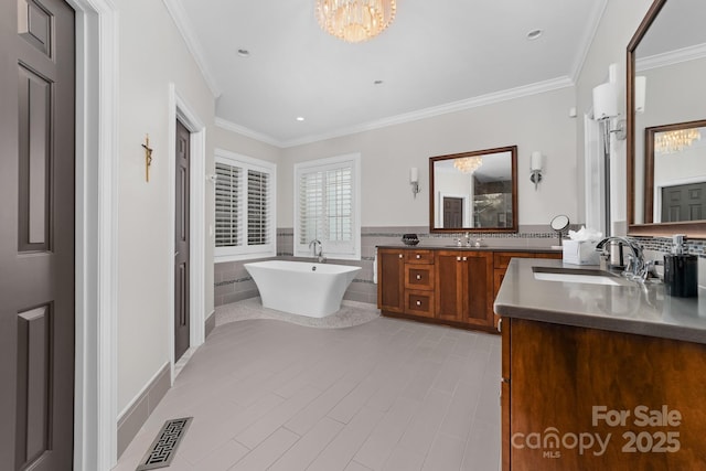 bathroom with a sink, a soaking tub, a notable chandelier, and visible vents