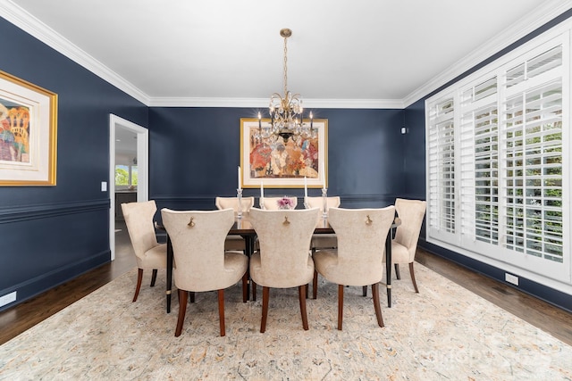 dining area with crown molding, an inviting chandelier, and wood finished floors
