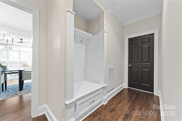 mudroom with baseboards, visible vents, ornamental molding, and dark wood-type flooring