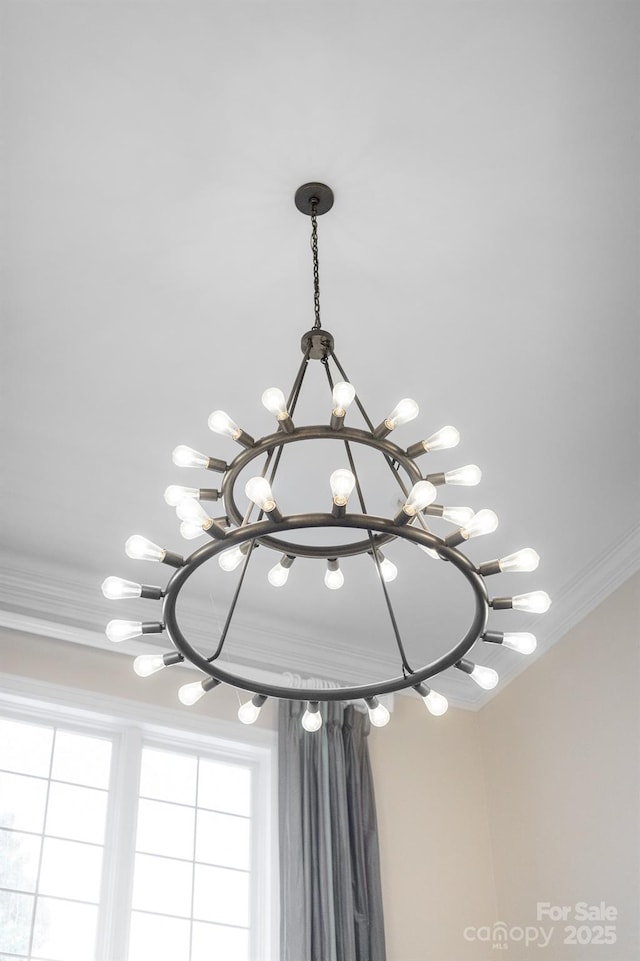 details featuring crown molding and a chandelier
