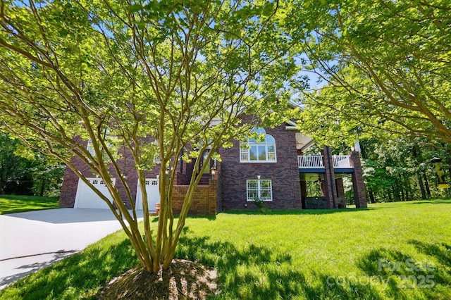 view of front facade with brick siding, driveway, and a front yard