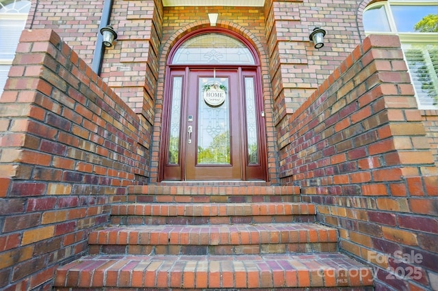 property entrance featuring brick siding