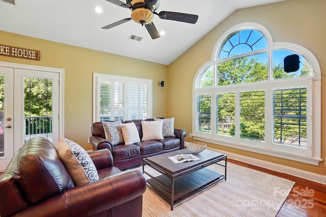 living area featuring visible vents, wood finished floors, a wealth of natural light, and vaulted ceiling