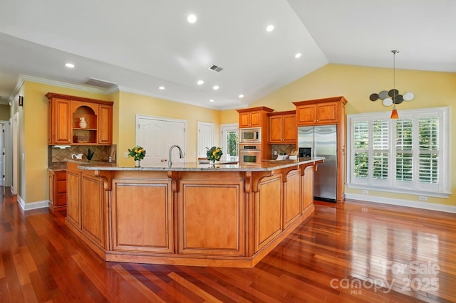 kitchen with brown cabinetry, a kitchen bar, open shelves, light stone countertops, and stainless steel appliances