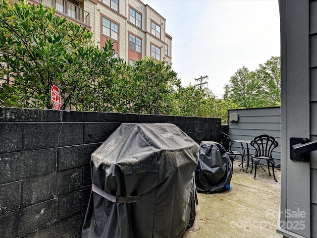 view of patio with area for grilling and fence