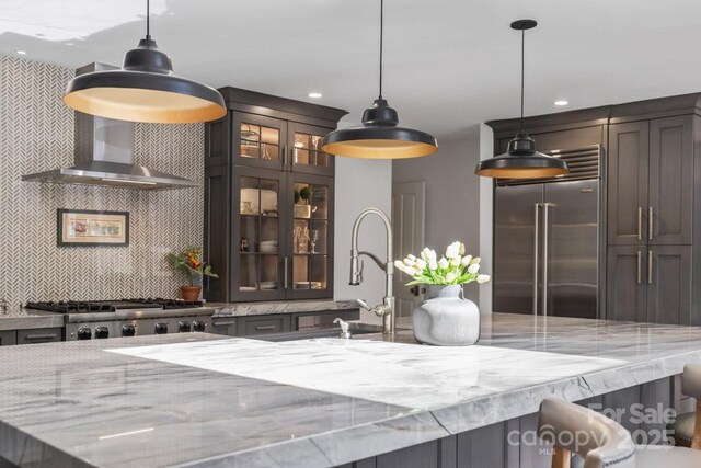 interior space featuring range, stainless steel built in fridge, decorative light fixtures, tasteful backsplash, and recessed lighting