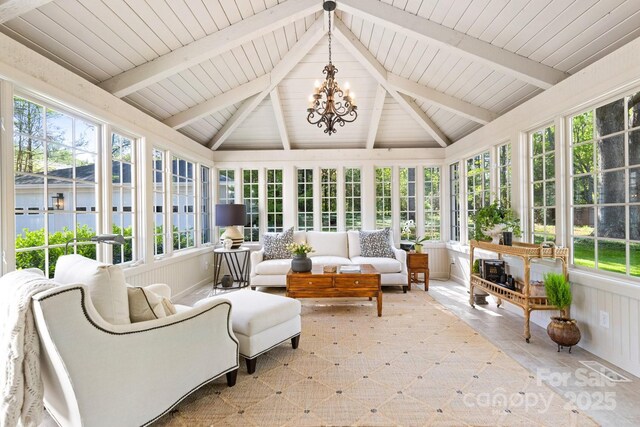 sunroom / solarium with lofted ceiling with beams, a notable chandelier, plenty of natural light, and visible vents