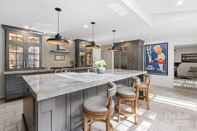 kitchen featuring recessed lighting, built in refrigerator, gray cabinetry, and baseboards