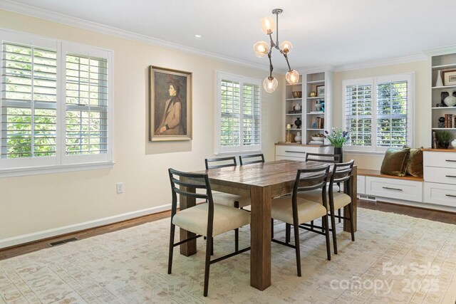 dining space with crown molding, baseboards, and wood finished floors