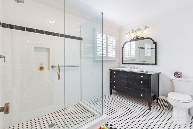 bathroom featuring vanity, toilet, baseboards, ornamental molding, and a stall shower