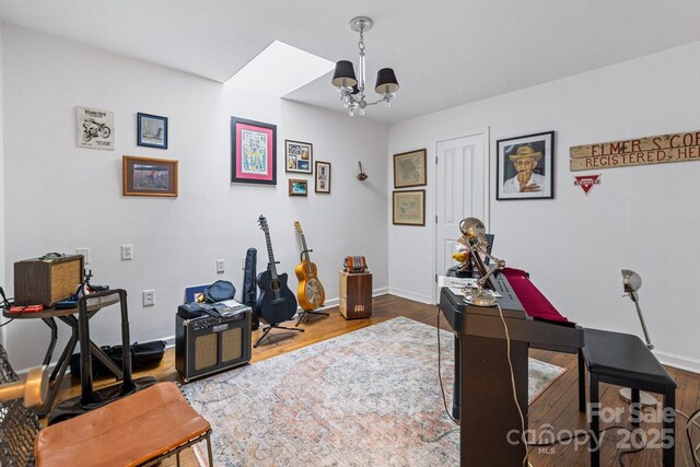office area featuring an inviting chandelier, baseboards, and wood finished floors