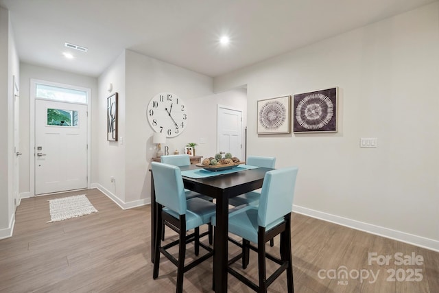 dining space with baseboards, recessed lighting, wood finished floors, and visible vents