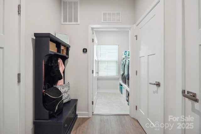 mudroom with baseboards, visible vents, and wood finished floors
