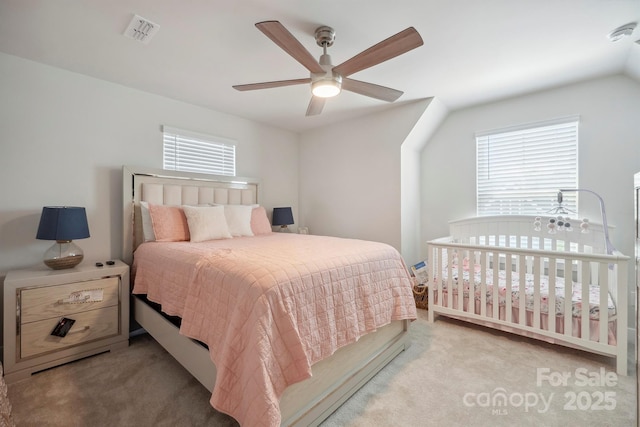 carpeted bedroom featuring a ceiling fan, visible vents, and multiple windows