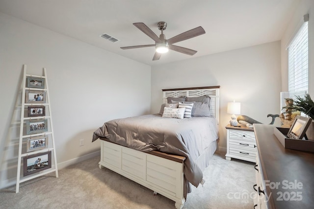 bedroom with visible vents, a ceiling fan, baseboards, and light carpet