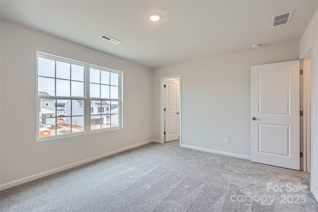 carpeted empty room with baseboards and visible vents