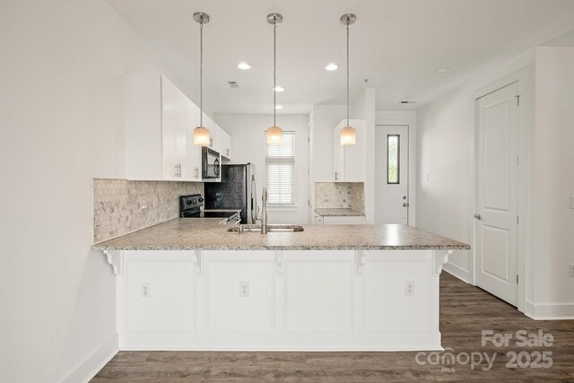 1101 W 1st St Unit 408, Charlotte, NC 28202 - kitchen featuring a peninsula, stainless steel electric range oven, a sink, backsplash, and a breakfast bar