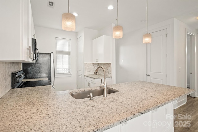 1101 W 1st St Unit 408, Charlotte, NC 28202 - kitchen with a sink, white cabinets, stainless steel appliances, light stone counters, and decorative backsplash