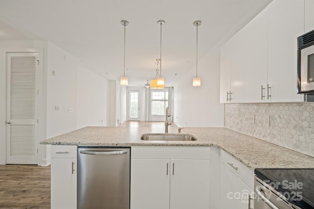 1101 W 1st St Unit 408, Charlotte, NC 28202 - kitchen featuring appliances with stainless steel finishes, a sink, a peninsula, decorative backsplash, and white cabinetry