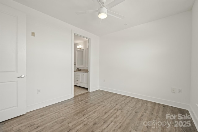 1101 W 1st St Unit 408, Charlotte, NC 28202 - unfurnished bedroom featuring wood finished floors, baseboards, ensuite bath, and a ceiling fan