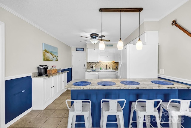 9660 Shore Dr Unit 208, Myrtle Beach, SC 29572 - kitchen with ceiling fan, a breakfast bar area, white cabinets, a peninsula, and white appliances