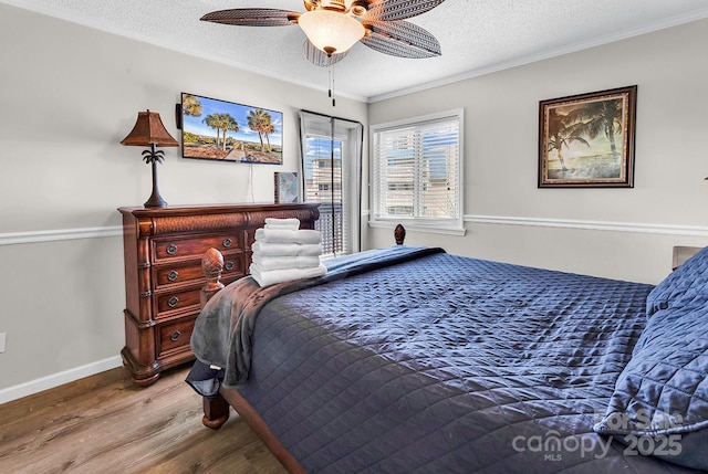 9660 Shore Dr Unit 208, Myrtle Beach, SC 29572 - bedroom with crown molding, a textured ceiling, a ceiling fan, baseboards, and wood finished floors