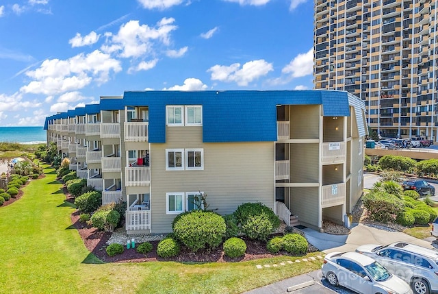 9660 Shore Dr Unit 208, Myrtle Beach, SC 29572 - view of building exterior with a water view and uncovered parking