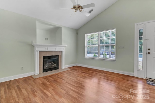unfurnished living room featuring high vaulted ceiling, light wood-style flooring, ceiling fan, a fireplace, and baseboards