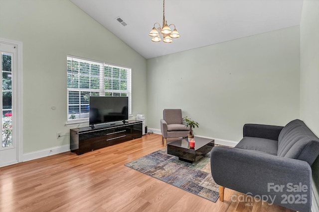 living area featuring a chandelier, wood finished floors, baseboards, and high vaulted ceiling