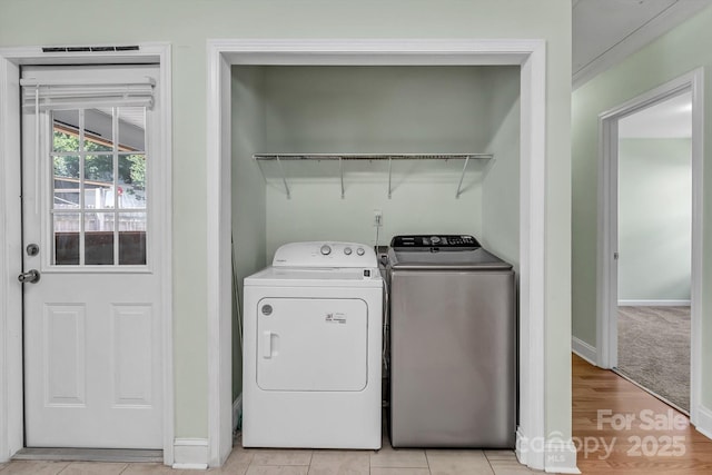 washroom with separate washer and dryer and baseboards