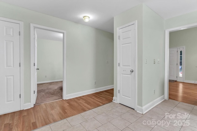 unfurnished bedroom with light wood-style flooring and baseboards
