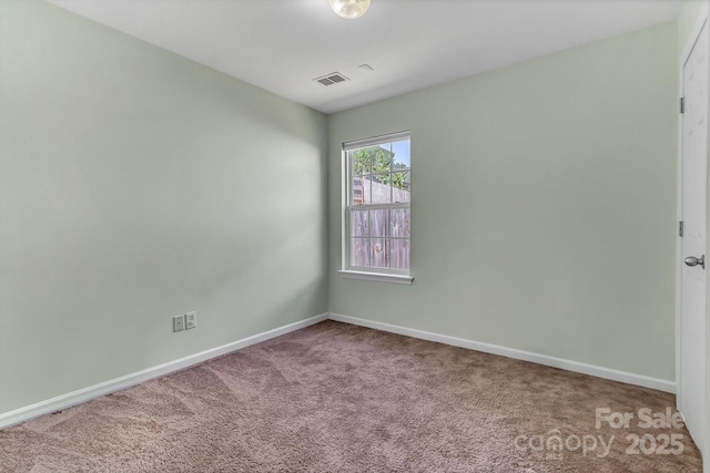 carpeted spare room featuring baseboards