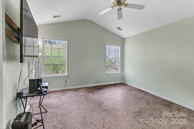 carpeted empty room featuring vaulted ceiling, a ceiling fan, and baseboards