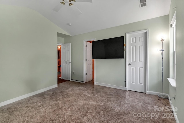 unfurnished bedroom featuring lofted ceiling, carpet floors, baseboards, and ceiling fan