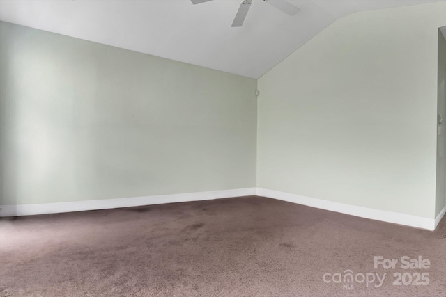 empty room with carpet flooring, a ceiling fan, lofted ceiling, and baseboards