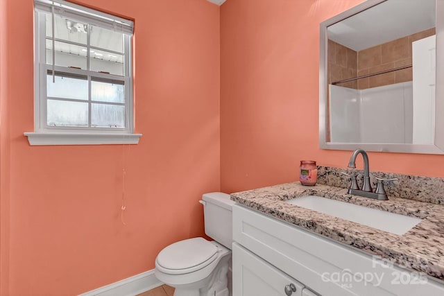 bathroom featuring toilet, vanity, baseboards, and tile patterned floors