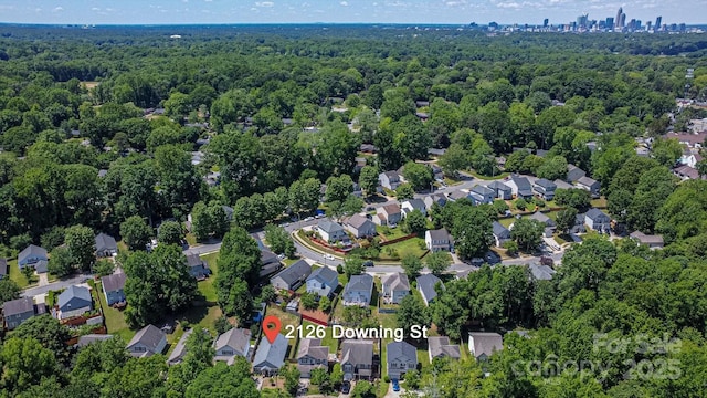 view of property location with a forest and nearby suburban area